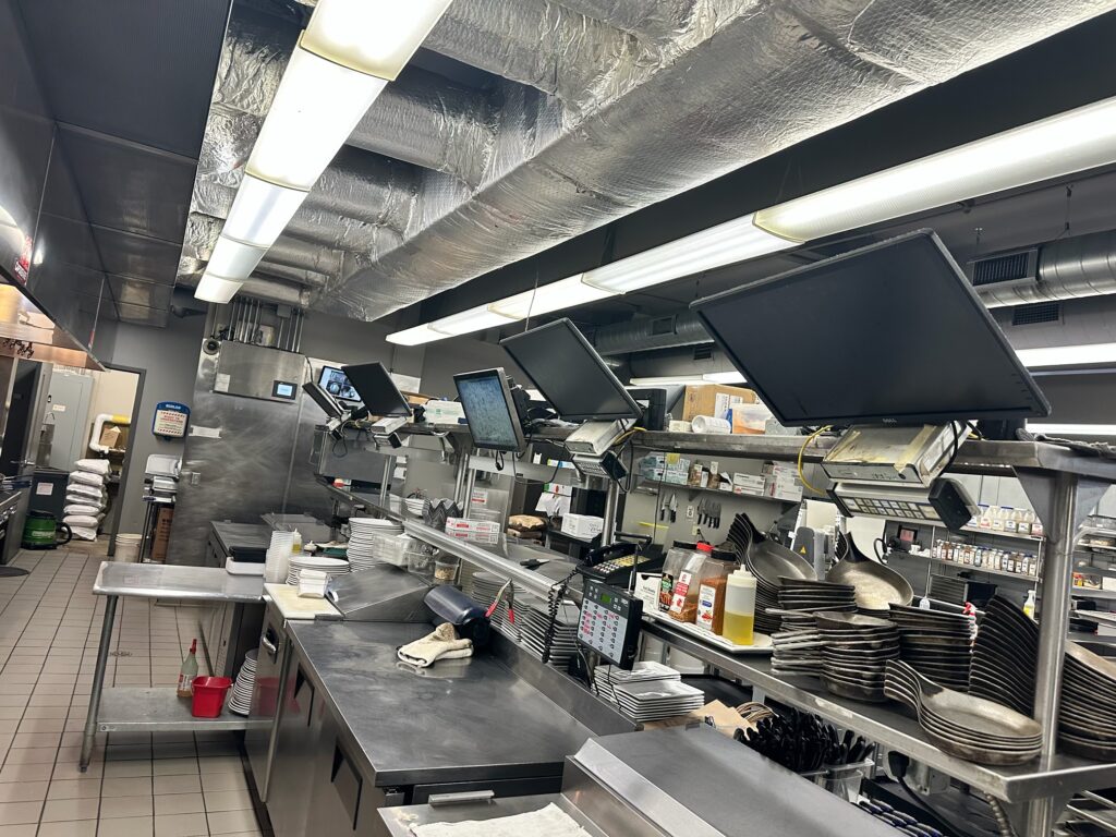 Busy restaurant pass with monitors and plates